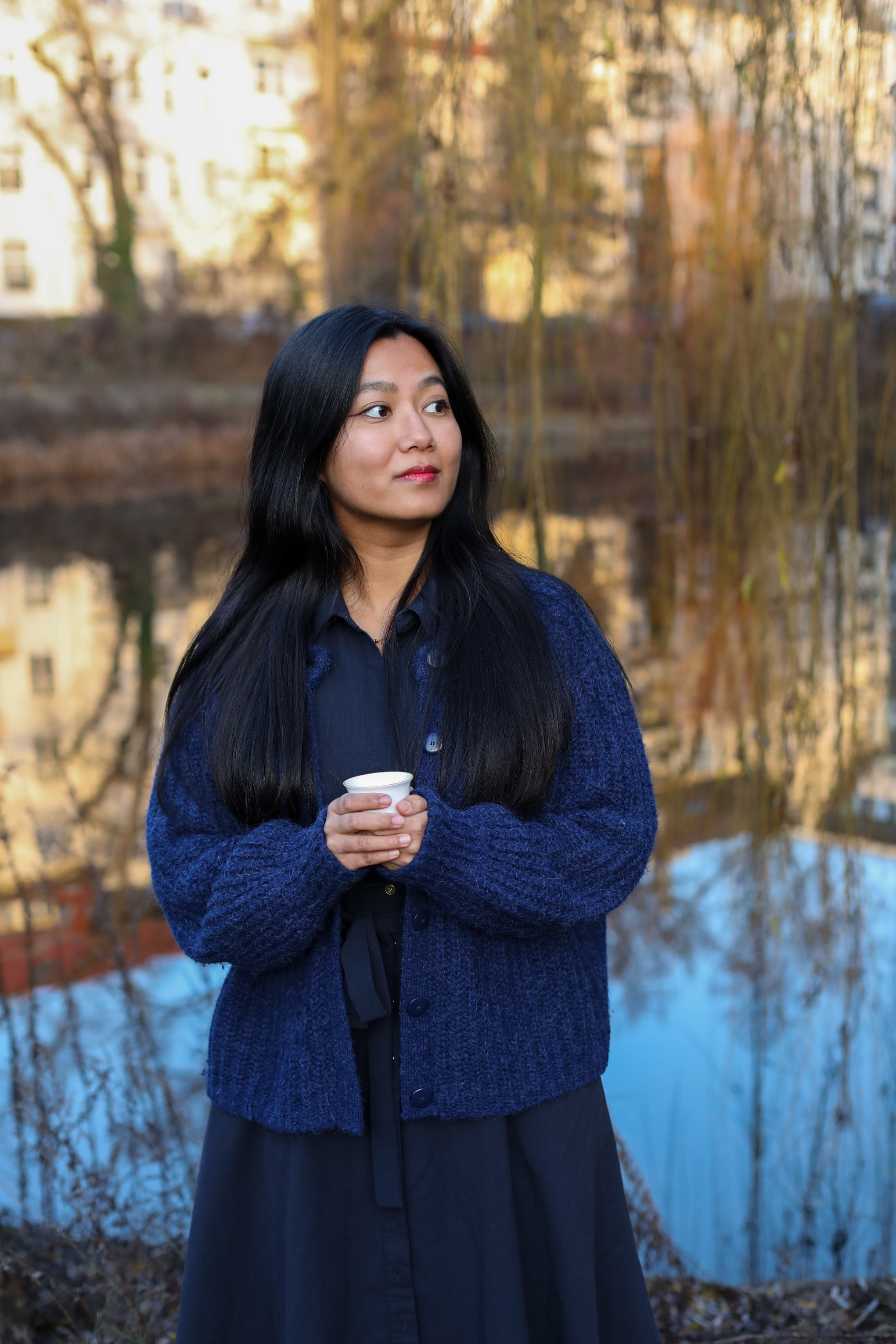 Swikriti, founder of Darjeeling Cup, holding a tea cup in Berlin
