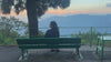 Swikriti, founder of Darjeeling Cup, sitting on a bench overlooking the Himalayan hills at sunset
